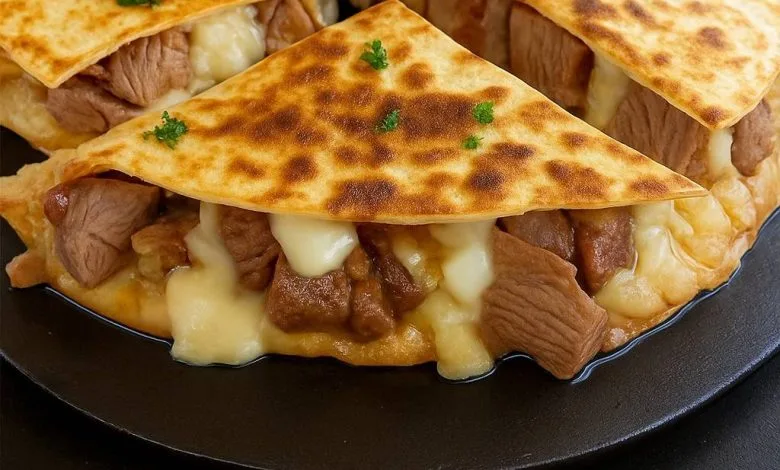 Steak and cheese quesadillas cut into wedges, served hot with melted cheese