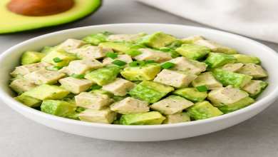 Keto Avocado Chicken Salad in a white bowl with fresh avocado and chicken
