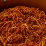 Ground beef spaghetti in a large pot, mixed with rich tomato sauce and no sausage