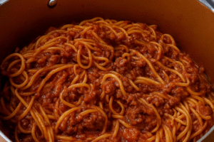 Ground beef spaghetti in a large pot, mixed with rich tomato sauce and no sausage