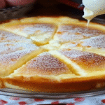 Japanese cotton cheesecake sliced and dusted with powdered sugar, drizzled with condensed milk