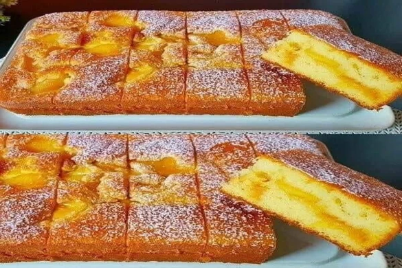 Golden and moist 5-Minute Cake dusted with powdered sugar and sliced to show its fluffy texture.