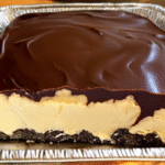 No-bake chocolate eclair cake with layers of graham crackers, vanilla pudding, whipped topping, and chocolate frosting in a pan