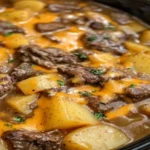 Old-Fashioned Amish Beef and Potato Casserole with layers of tender beef, creamy mushroom sauce, and melted cheddar cheese, served hot.
