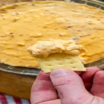 Close-up of Red Lantern Cheese Dip – creamy cheddar with bacon bits served with crackers