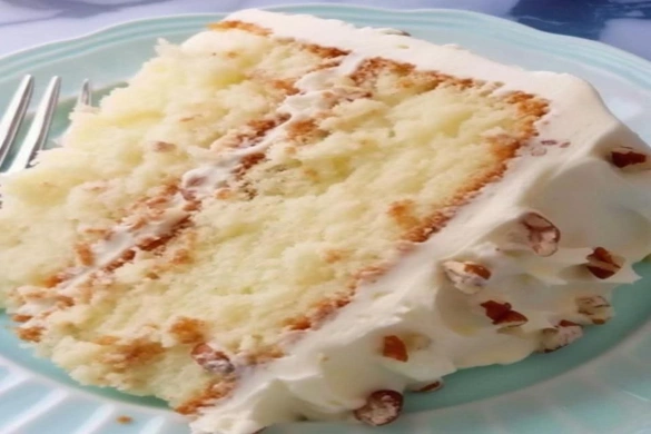 southern butter pecan layer cake slice with frosting and pecans