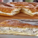Cream Cheese Cake with creamy layers sliced on a wooden board